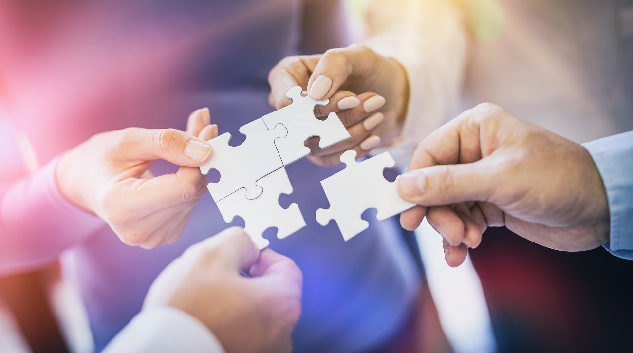 A group of business people assembling jigsaw puzzle. The concept of cooperation, teamwork, help and support in business.