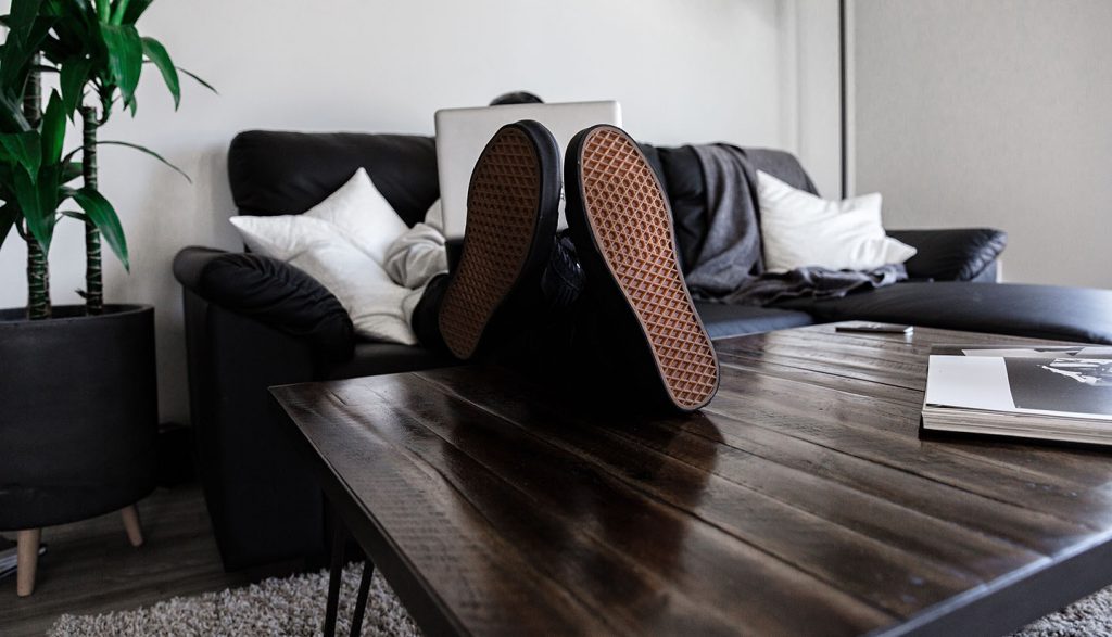 Man on a couh, shoes ontable works