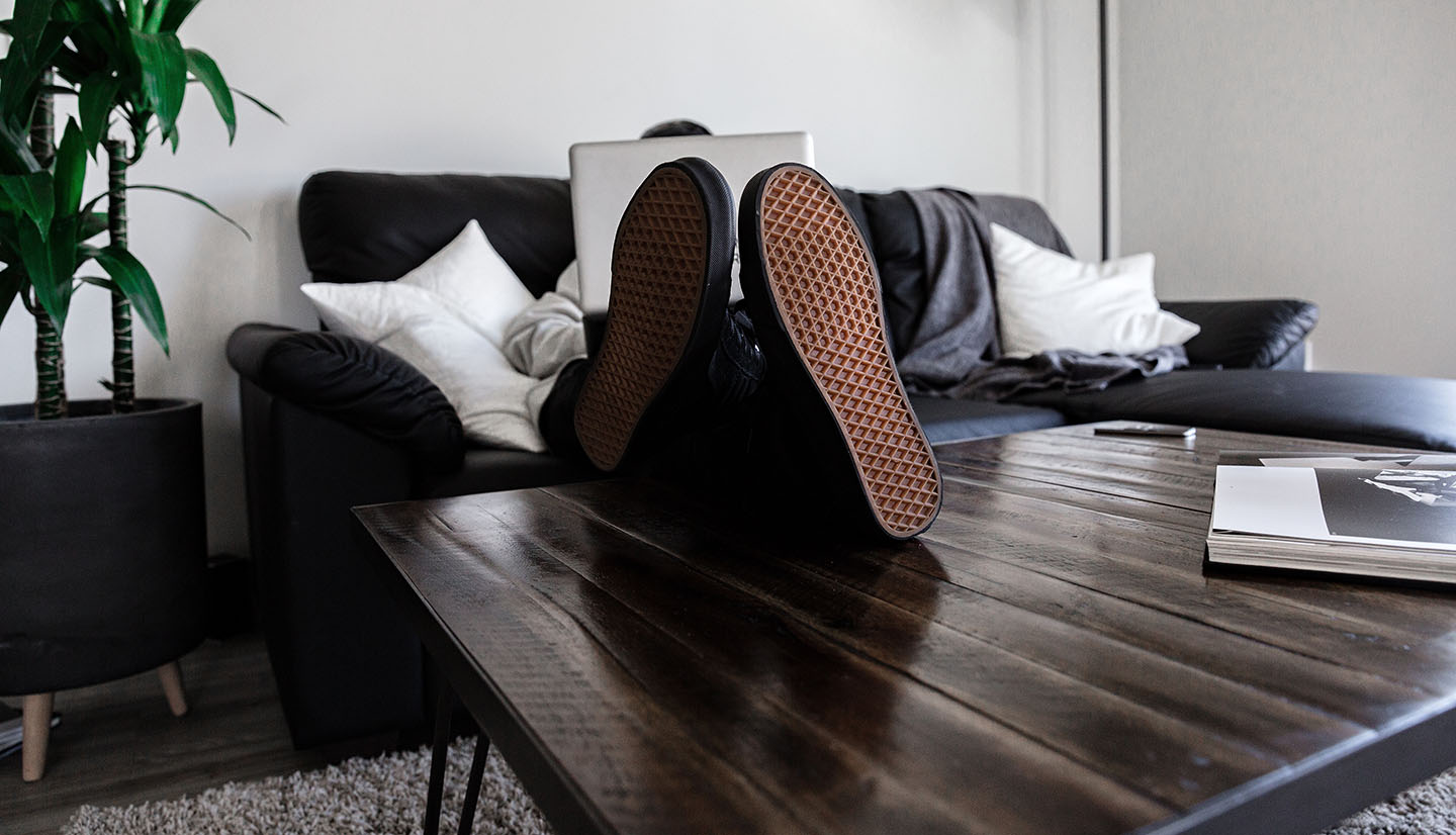 Man on a couh, shoes ontable works