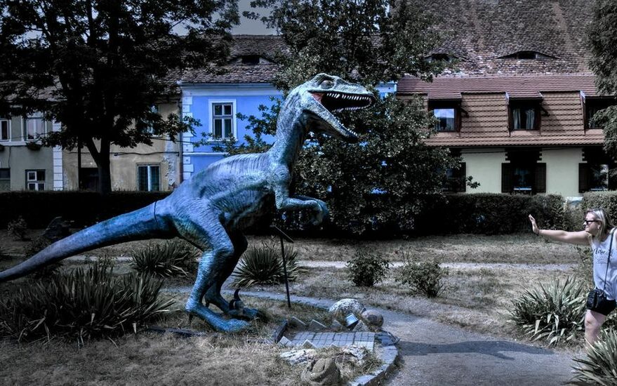 Igor Paszkiewicz – Shutterstock woman holding off a velociraptor statue