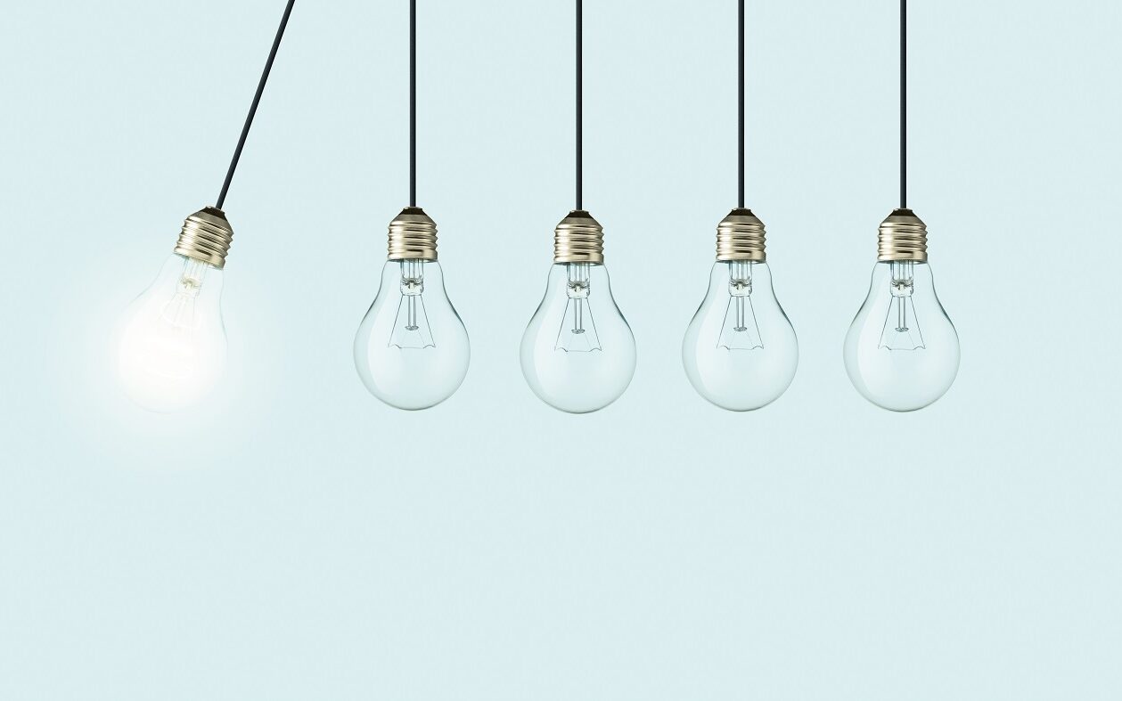 ©Alones / Shutterstock Five lightbulbs are hanging in a line. The left most lightblub is lit up and swinging towards the rest of the unlit lightbulbs.