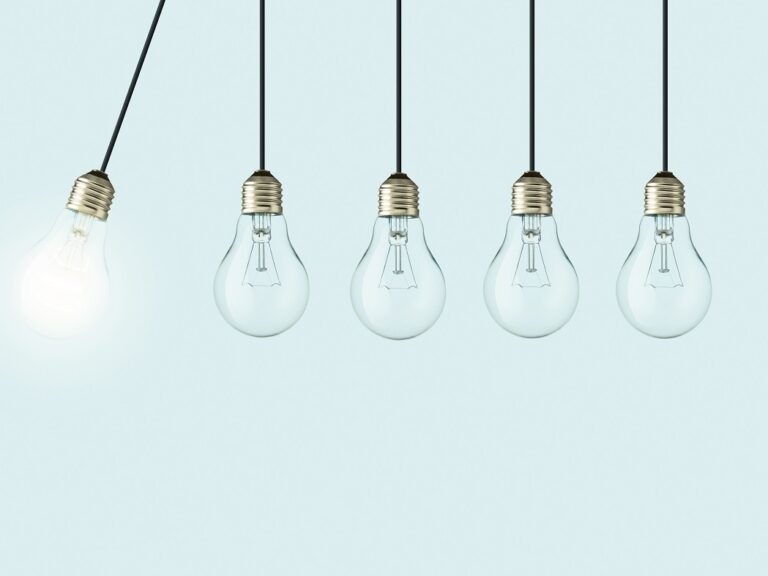 Five lightbulbs are hanging in a line. The left most lightblub is lit up and swinging towards the rest of the unlit lightbulbs.