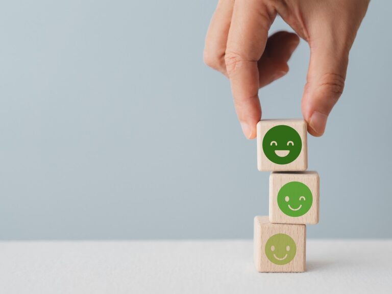 ©Ratana21 / Shutterstock A stack of 3 wooden blocks with happy faces on them that get progressively deeper green and happier as they move up the stack