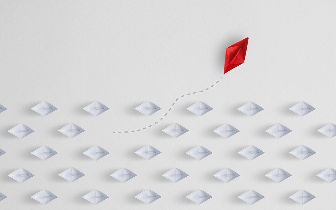 “Big companies have the capacity to be catalysts for change.” © Adobe Stock – Studio_East Image of a paper boat sailing away from the group of paper boats