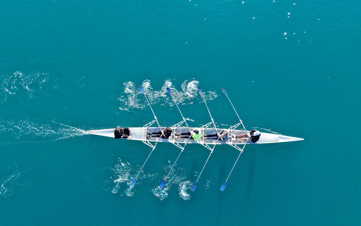 ©Aerial Motion/Shutterstock Photo of a rowing team rowing on the water.