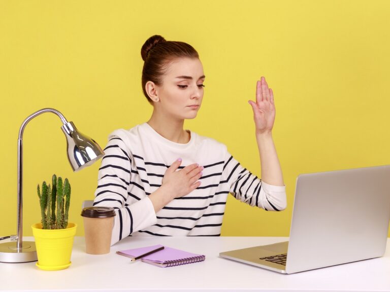 woman raising her hand to make a promess to her colleagues at a distance