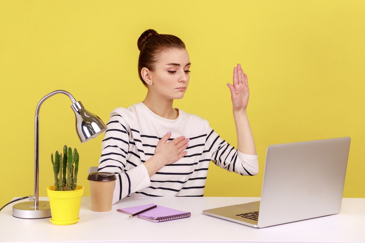 woman raising her hand to make a promess to her colleagues at a distance