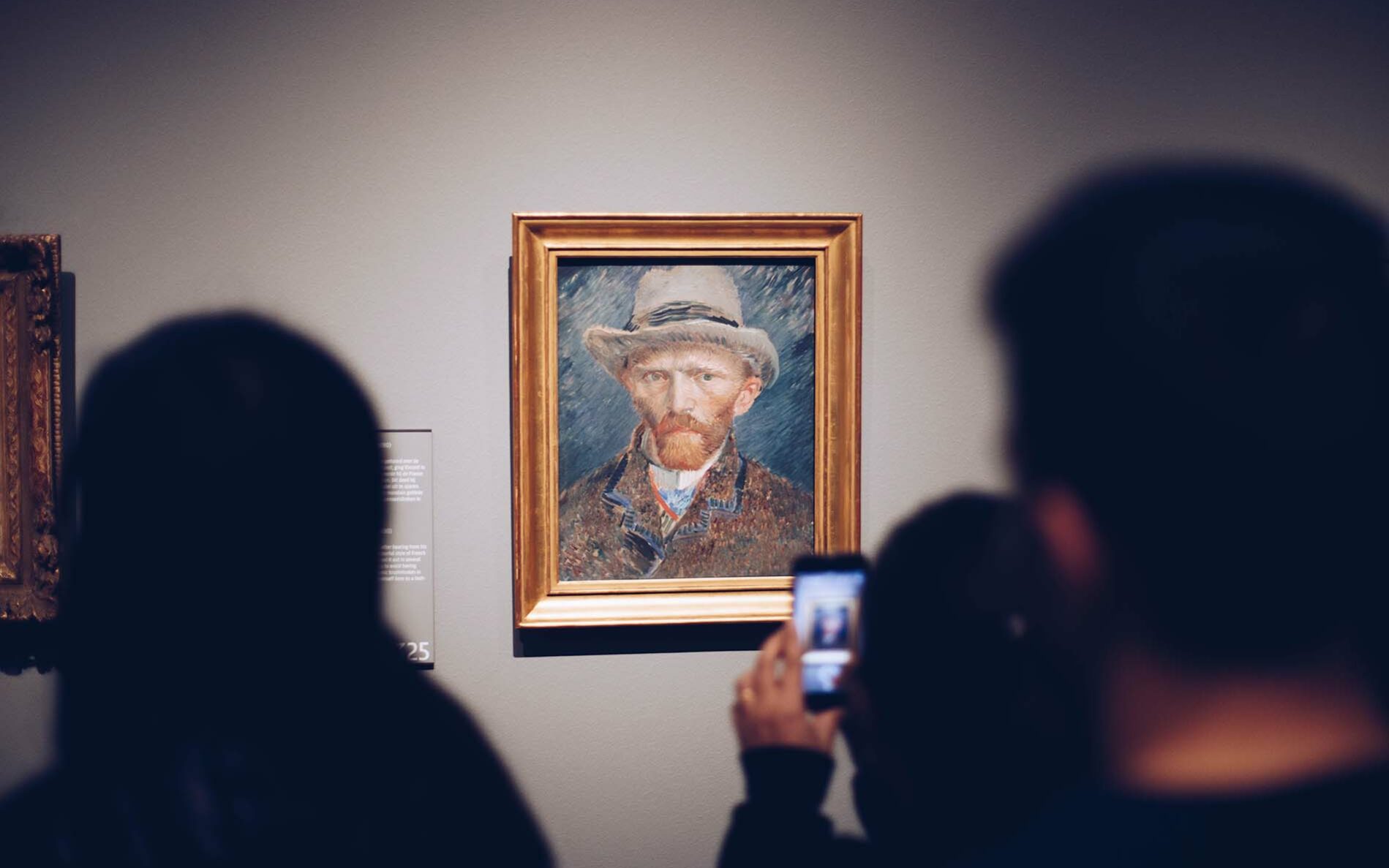 Feature photo by Stale Grut/Unsplash Photo of someone taking a picture of a Vincent VanGogh portrait in a museum.
