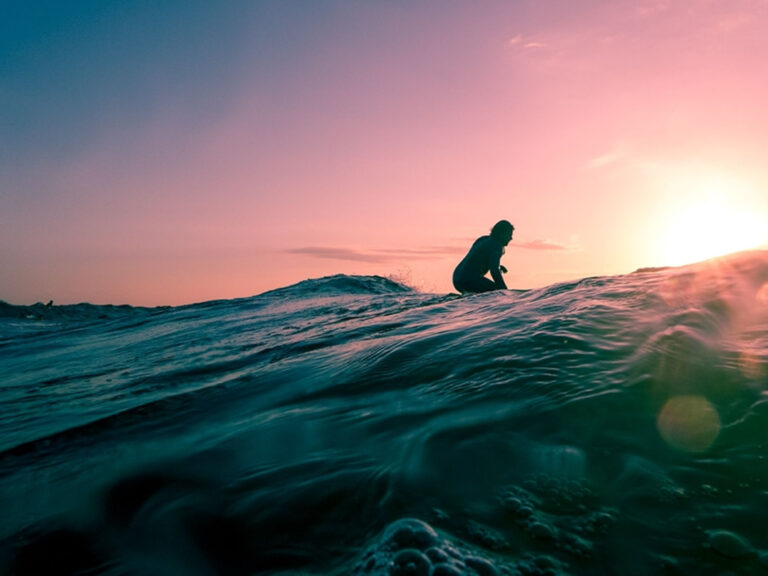 Man surfing on ocean water during golden hour, © Linus Nylund / Unspash