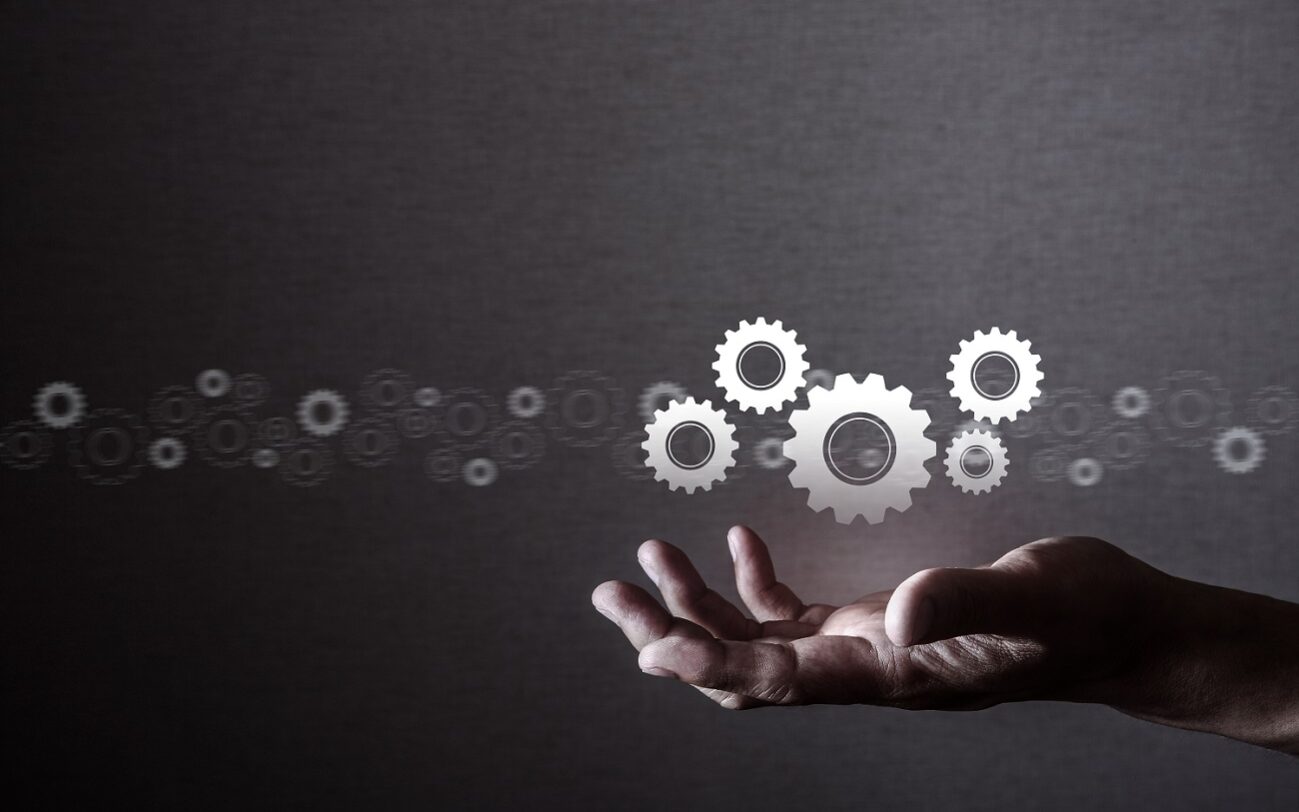 Taa22/AdobeStock Human manipulating gears, technology.