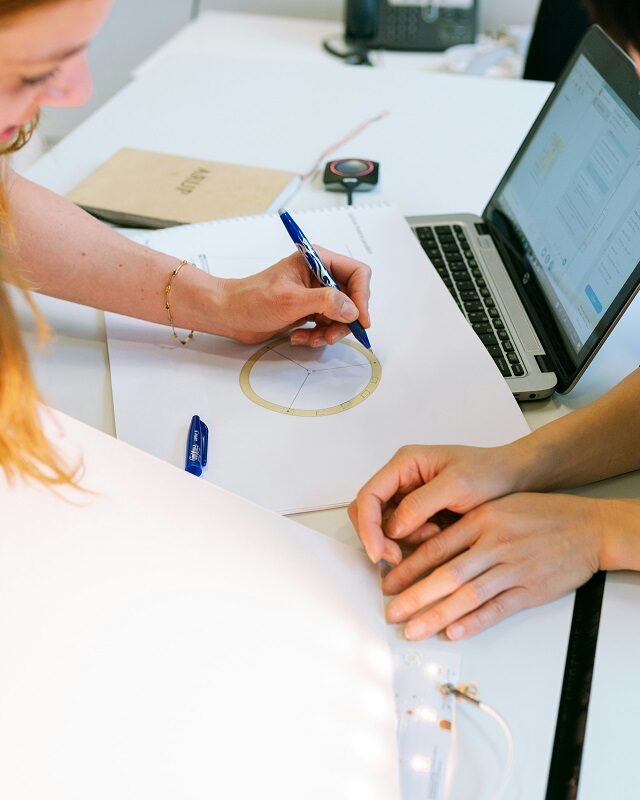 ©This is Engineering / Unsplash Two people lean over a drawing working on an idea together