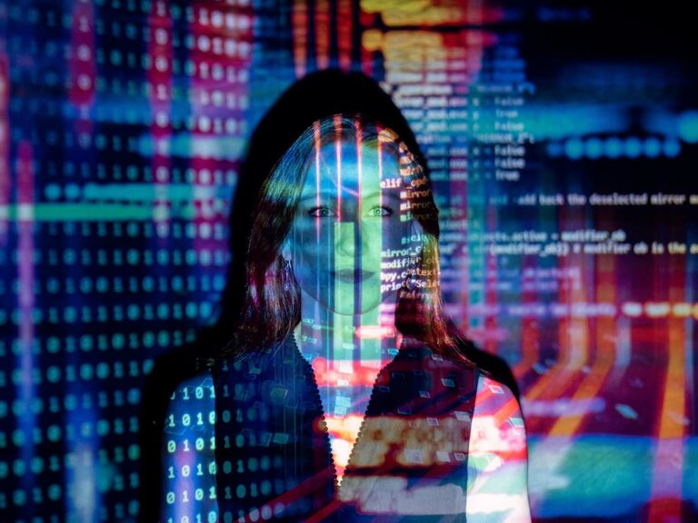 Women in tech and science. Photo of a woman with code projected on to her face.