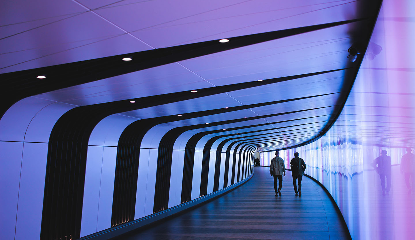 Man walking through pathway, © Tom Parkes / Unsplash