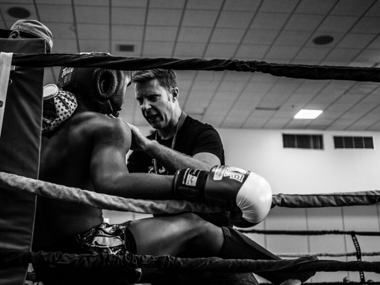 Photo of a boxing coaching talking to the boxer during a match