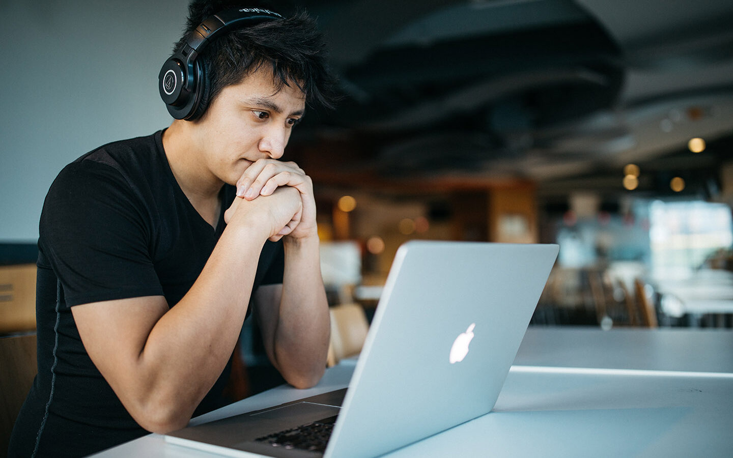 @Wes Hicks / Unsplash Man wearing headphones while sitting on chair in front of MacBook, Wes Hicks, Unsplash