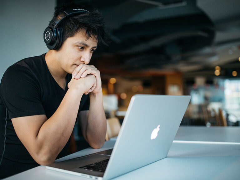 Man wearing headphones while sitting on chair in front of MacBook, Wes Hicks, Unsplash