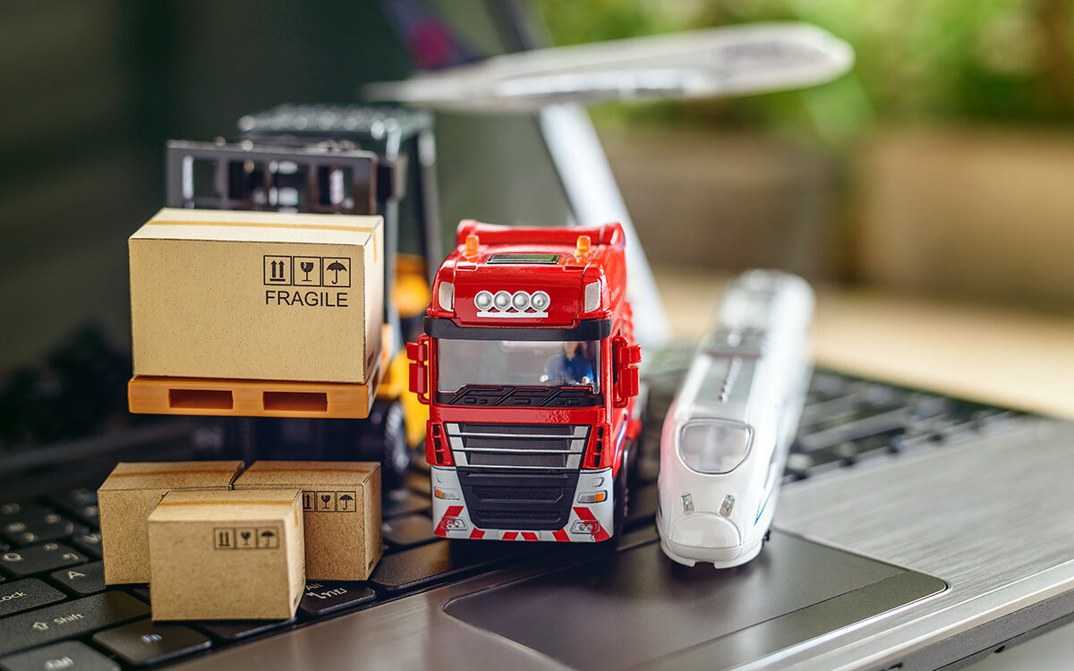 William W. Potter – AdobeStock Transport truck, air plane, hi-speed train, fork-lift moves a box / cartons on laptop computer, depicts delivering goods or products