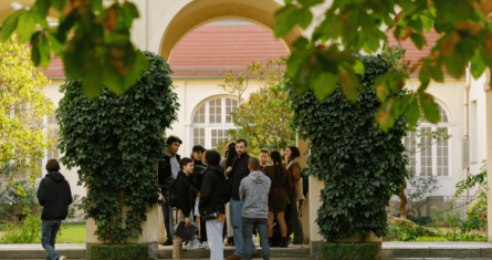 A group of students standing outside near a garden